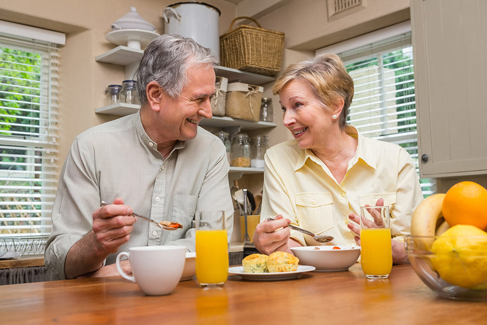 Senior couple eating breakfast in kitchen
