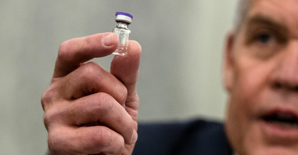 Man holding vile with coronavirus vaccine in hand