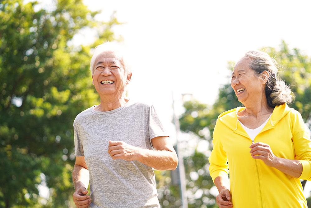 Senior couple jogging and smiling outside