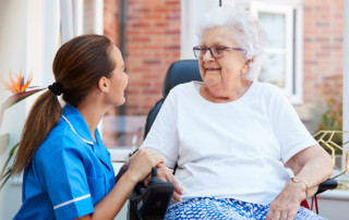 Senior woman with caregiver outside of assisted living community