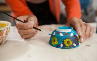 Senior painting small bowl with flowers
