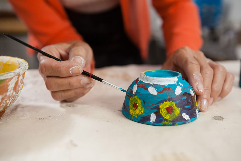 Senior painting small bowl with flowers