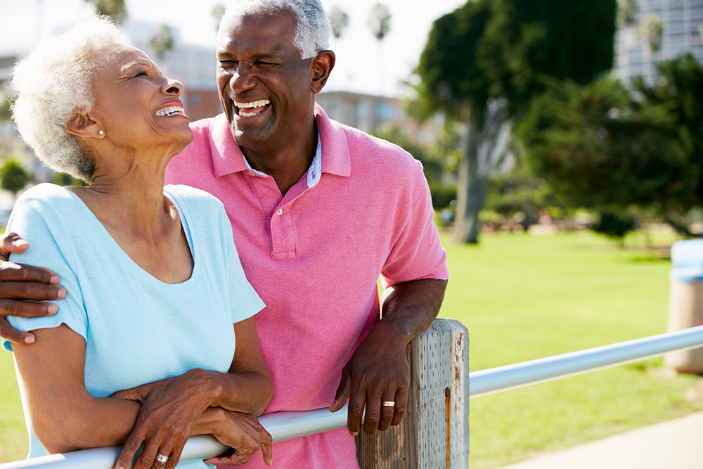 Senior couple laughing outside independent living community