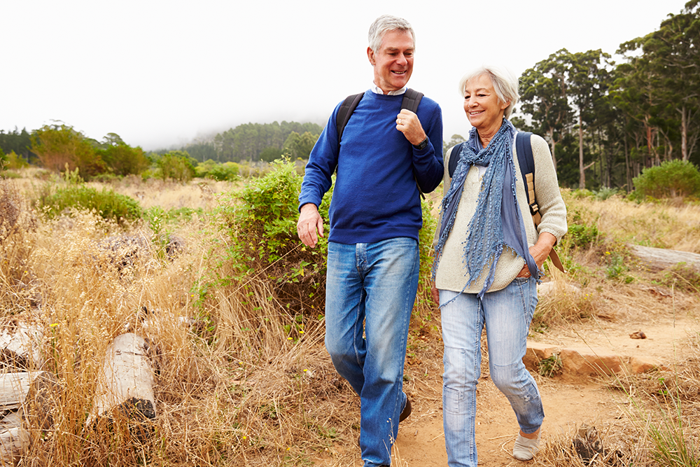 Senior couple hiking, smiling and happy