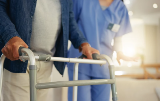 Senior man, person with disability and walking frame for support, nurse and handholding